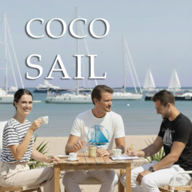 Eleganckie koszulki żeglarskie w stylu marynistycznym. Kobieta w koszulce w paski oraz mężczyźni w białej i czarnej koszulce żeglarskiej z nadrukiem, siedzący przy stoliku na plaży z widokiem na jachty.