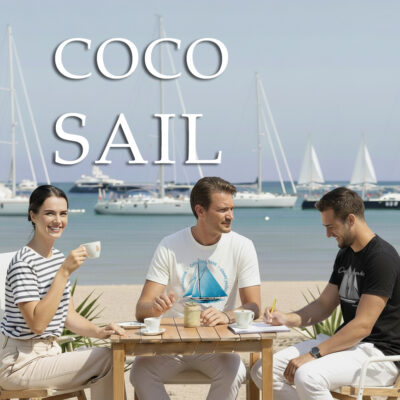 Eleganckie koszulki żeglarskie w stylu marynistycznym. Kobieta w koszulce w paski oraz mężczyźni w białej i czarnej koszulce żeglarskiej z nadrukiem, siedzący przy stoliku na plaży z widokiem na jachty.